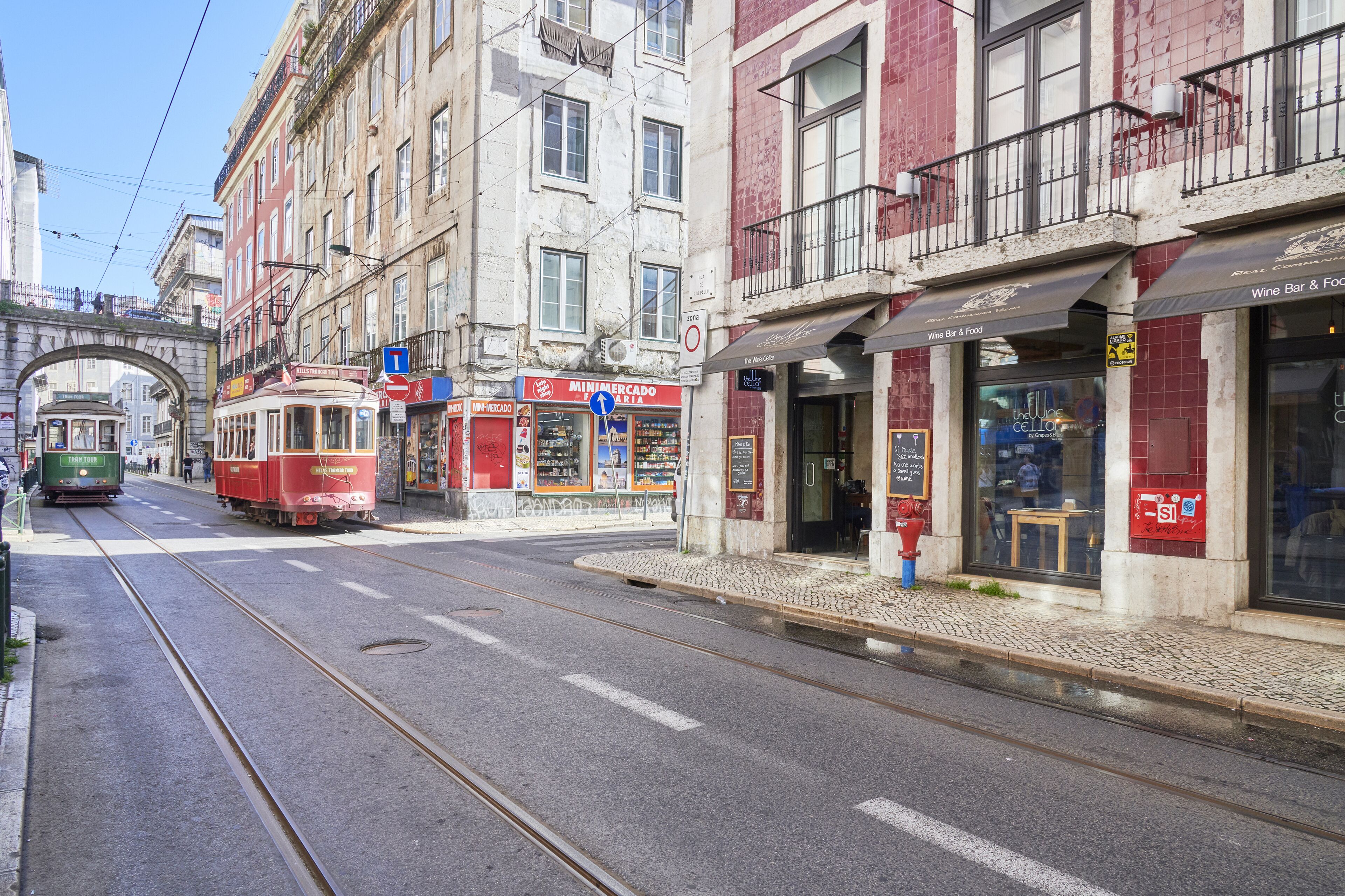 Eine Straße mit einer Straßenbahn, Gebäuden und einer Brücke.