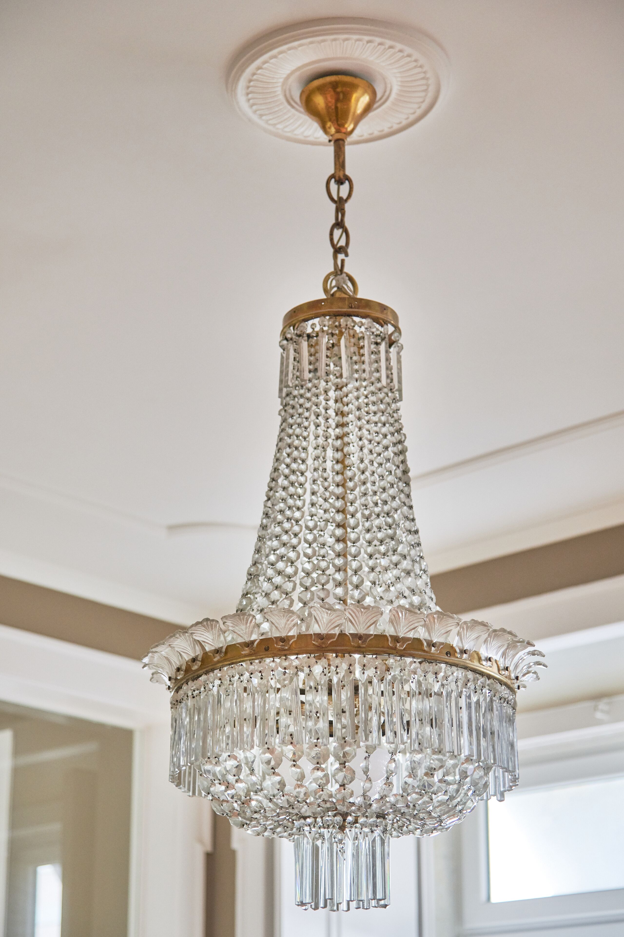A chandelier with a gold base and crystal decorations.
