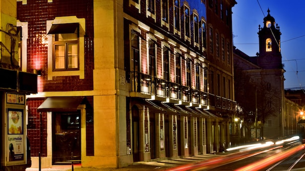 A historic building with a clock tower, large windows, and a tram line. - Lisbon Five Stars Apartments São Paulo 55 (Lisbon)