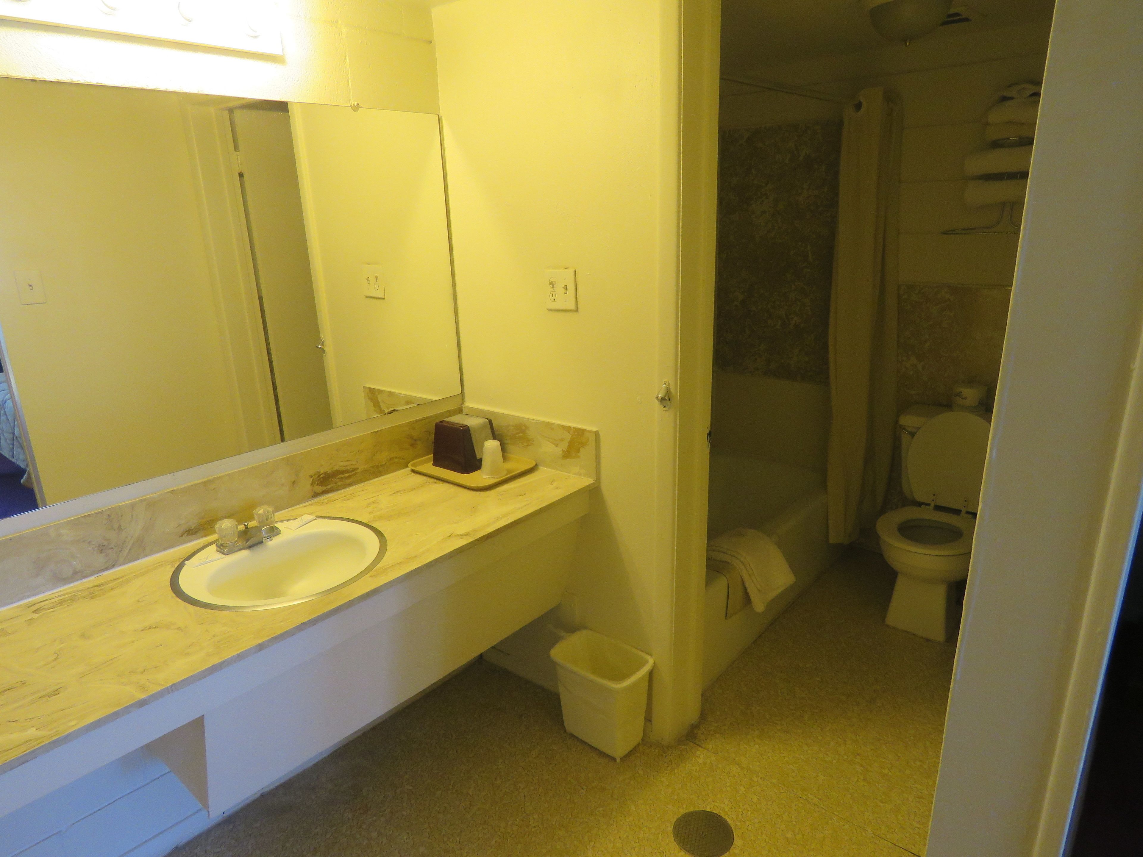A bathroom with a sink, mirror, and toilet.