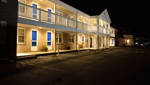 A two-story motel with a balcony on the upper floor, a parking lot in front, and a brick facade. - Cape Cod Harbor House Inn (Hyannis)