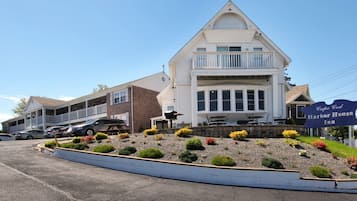 Stroll to the Cape Cod Harbor House Inn, where a charming balcony offers a view of the surrounding landscaped area.