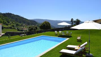 Alberca al aire libre por temporada y sombrillas en la alberca