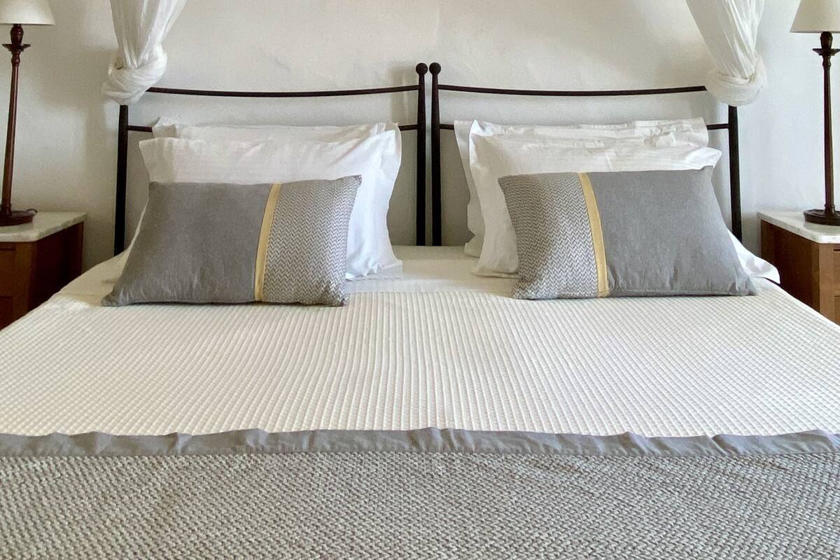 Ein Bett mit Baldachin, zwei Nachttische und eine Wand mit Dekoration.