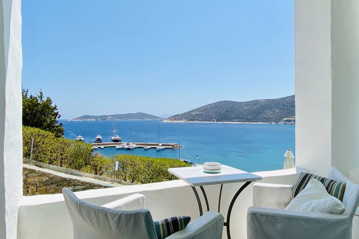 Ein Balkon mit Blick auf das Meer, ein Tisch und zwei Stühle.