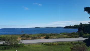 A coastal road with a view of the sea and distant land.