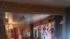 Um hall acolhedor decorado para o Natal, com árvore de Natal, área de estar e bandeira americana.