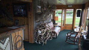 Um interior rústico com um balcão de madeira, um sofá e decorações de chifres.