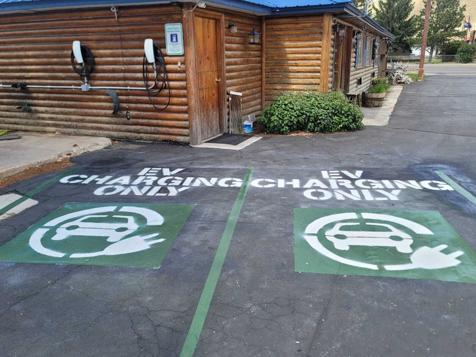 A building with EV charging stations marked on the pavement.