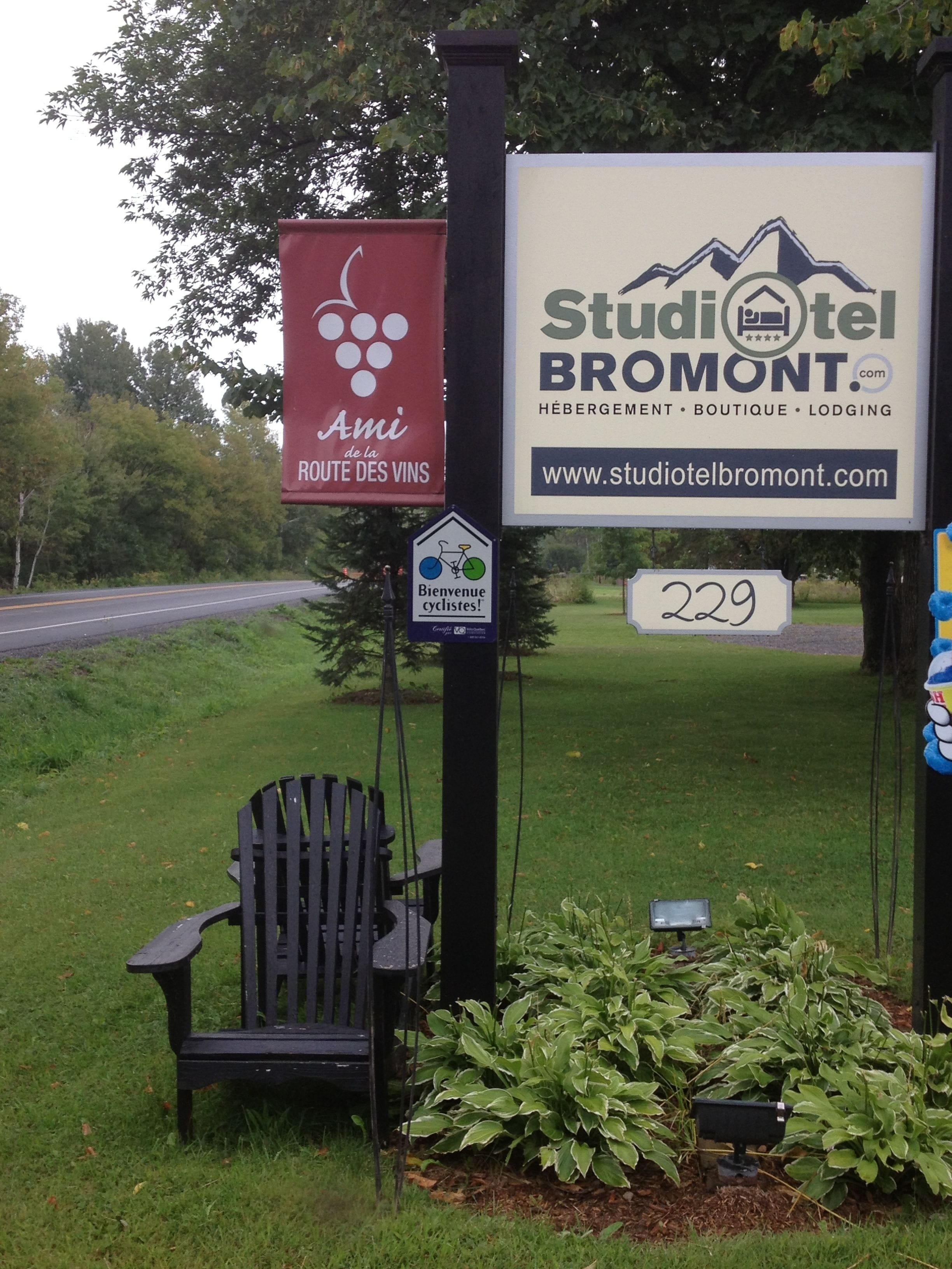 A sign for Studiotel Bromont with a website URL and a welcome sign for cyclists.