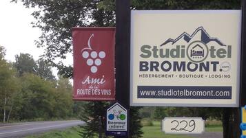 A sign for Studiotel Bromont with a website URL and a welcome sign for cyclists.