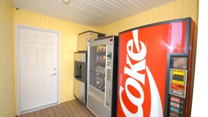 A room with a white door, a vending machine, and a snack machine.