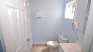 A bathroom with a toilet, a sink, and a towel rack.