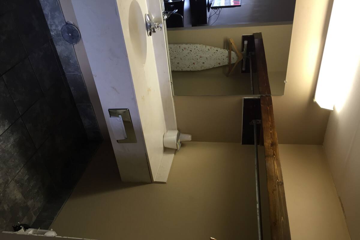 A bathroom with a toilet, a sink, and a mirror.