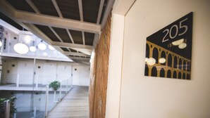 A corridor with a wooden floor, a sign with the number 205, and a modern interior design with circular lights. - Da Lapa Design Hotel - Hostel (Rio de Janeiro)