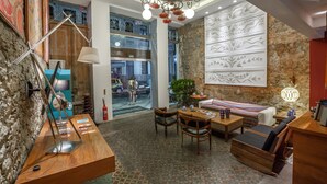 A hotel lobby with a wooden reception desk, seating area, and a large window overlooking the street. - Da Lapa Design Hotel - Hostel (Rio de Janeiro)