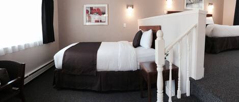 Una habitación de hotel con cama, una silla, una escalera y un cuadro en la pared.