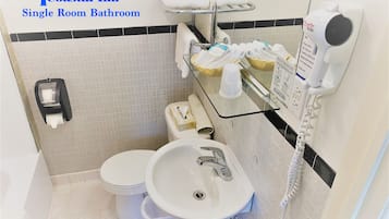 Une salle de bain individuelle comprenant des toilettes, un lavabo et un porte-serviettes.