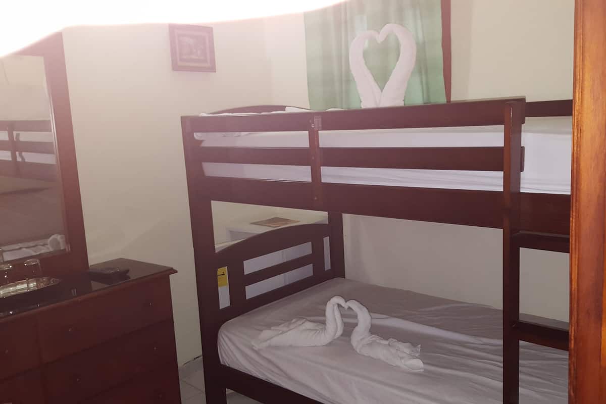 Een stapelbed met een witte matras en een handdoek versierd met een hartvorm.