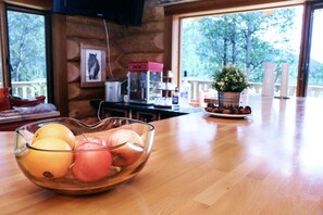 A wooden table with a glass bowl containing apples and oranges. - Rock Lake Lodge (Rock Lake)
