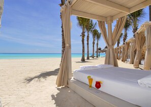 On the beach, white sand, sun loungers, beach volleyball