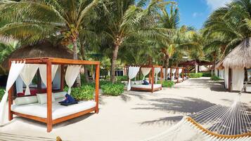 On the beach, white sand, sun loungers, beach umbrellas