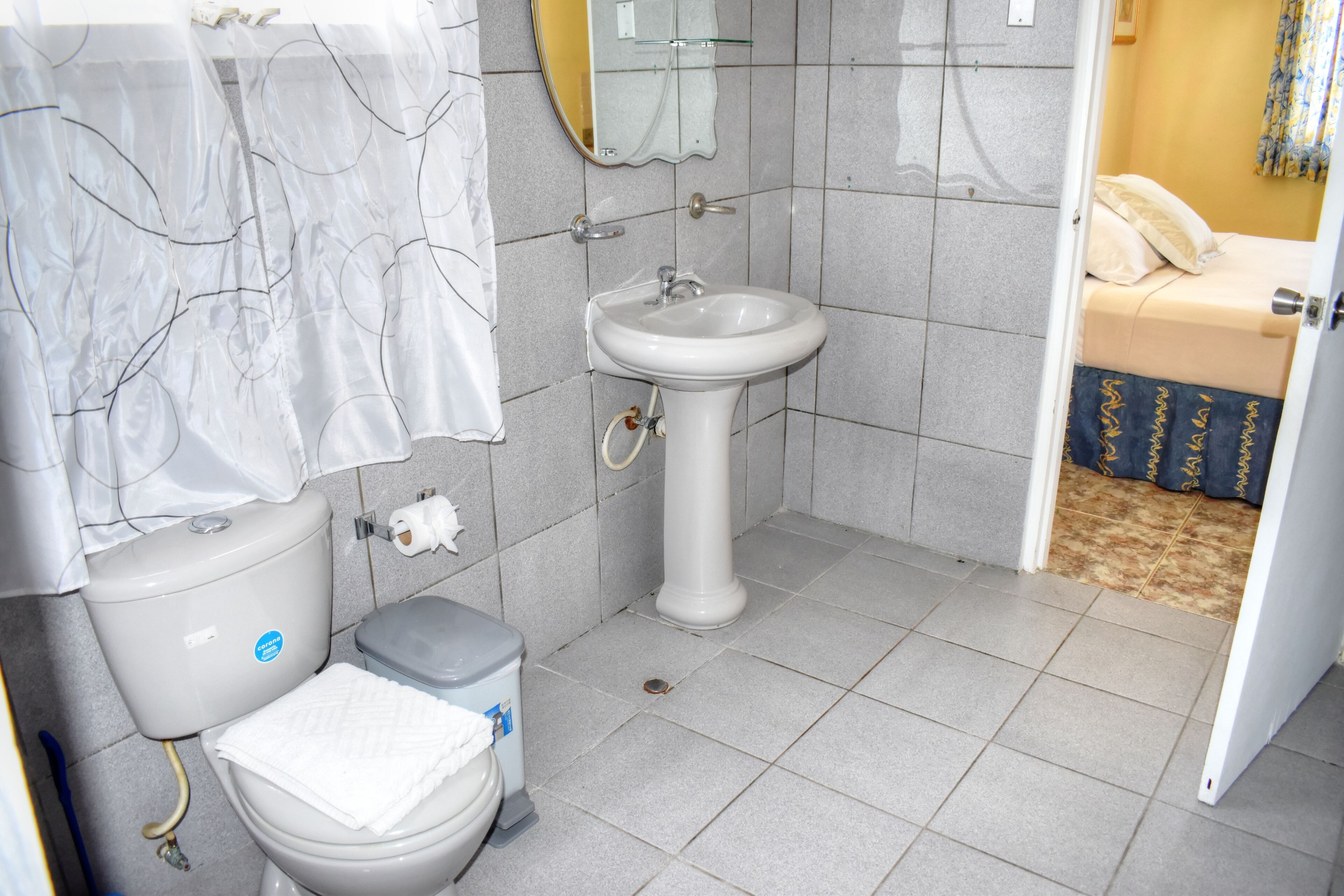 A bathroom with a toilet, sink, and shower area.