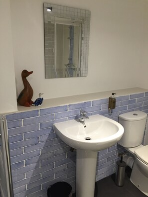 A bathroom with a white sink, a mirror, and a toilet.