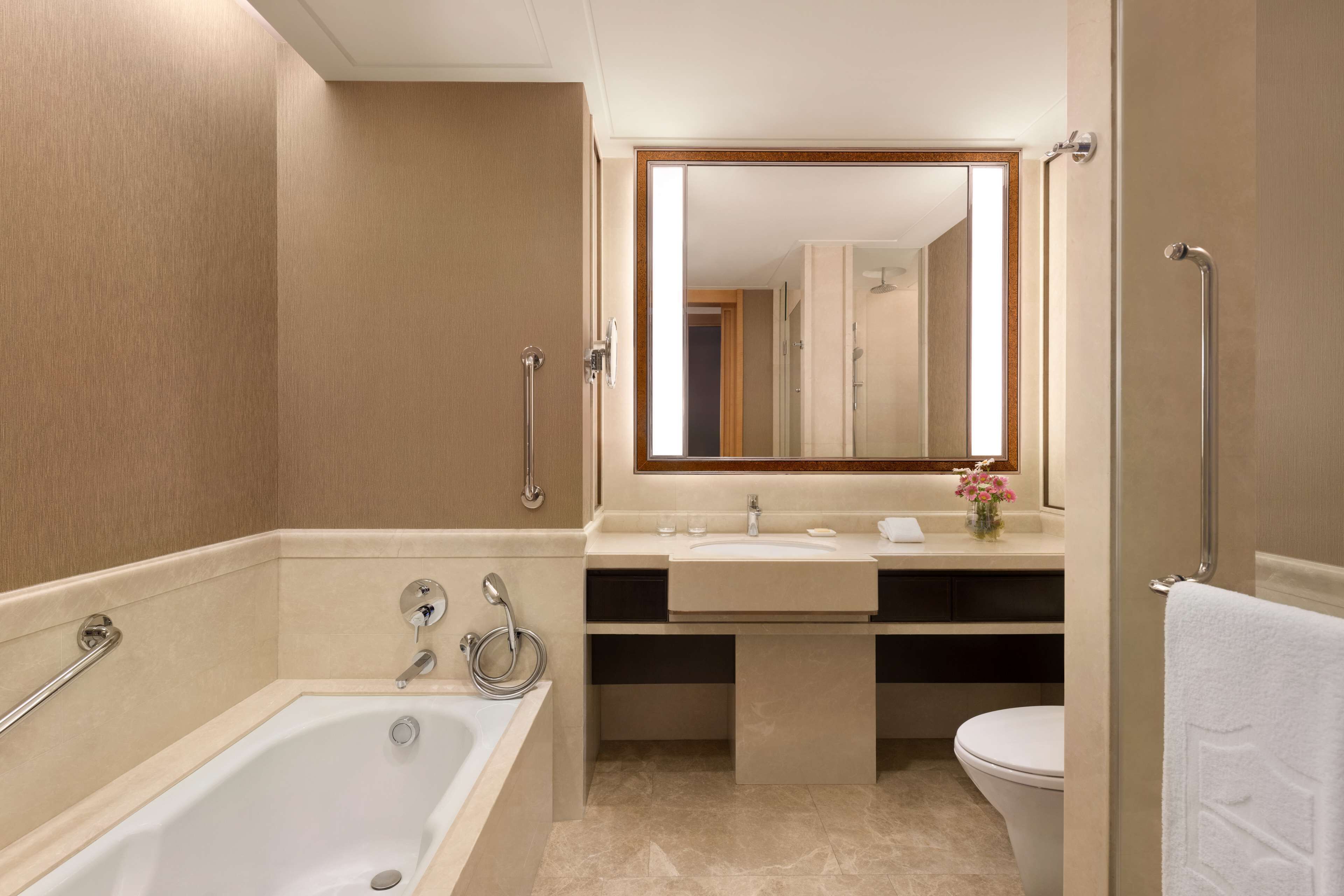 Un baño moderno con bañera, lavamanos e inodoro.