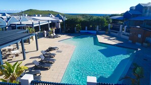 A swimming pool with lounge chairs and a view of the ocean. - Margaret River Beach Apartments (Gnarabup)
