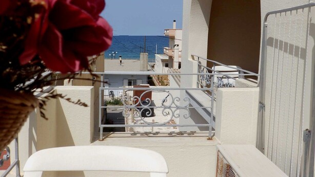 A balcony with a view of the sea, a white railing, and a white wall. - Alexandra Hotel (Chania)