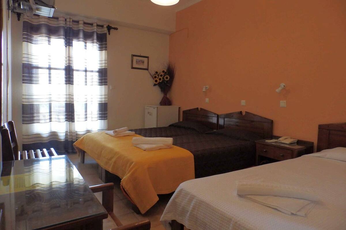 A hotel room with two beds, a desk, and a chair.