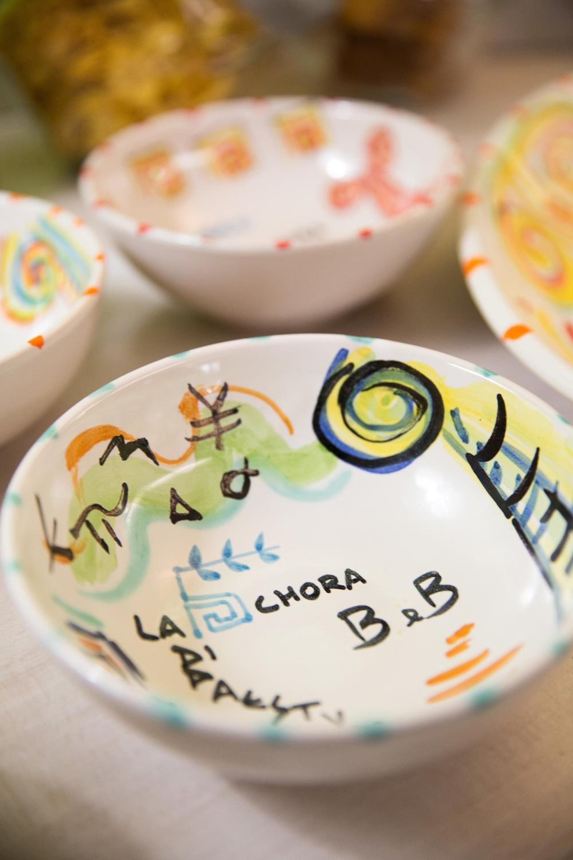 Primer pla d'un bol de ceràmica amb motius i lletres de colors.