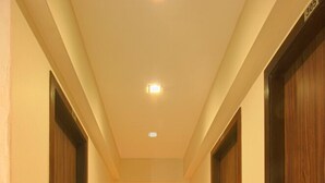 A hallway with wooden doors and a tiled floor.