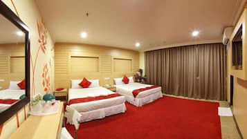 A hotel room with two beds, a large mirror, a wooden headboard, a red carpet, and a large window with curtains.