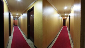 A hotel hallway with a red carpet, wooden walls, and doors leading to rooms. - GDS Hotel Kuala Lumpur (Kuala Lumpur)