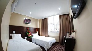 A hotel room with two beds, a large window with curtains, a painting on the wall, and a TV mounted on the wall. - GDS Hotel Kuala Lumpur (Kuala Lumpur)