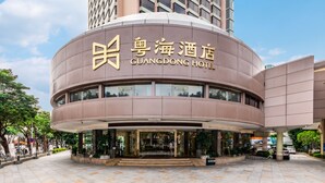 The exterior of the Guangdong Hotel with a modern design, featuring a curved facade and large windows. - Guangdong Hotel Zhuhai (Zhuhai)