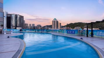 Una piscina al aire libre de temporada, sombrillas