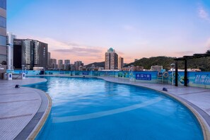 Una piscina con un paisaje urbano al fondo.