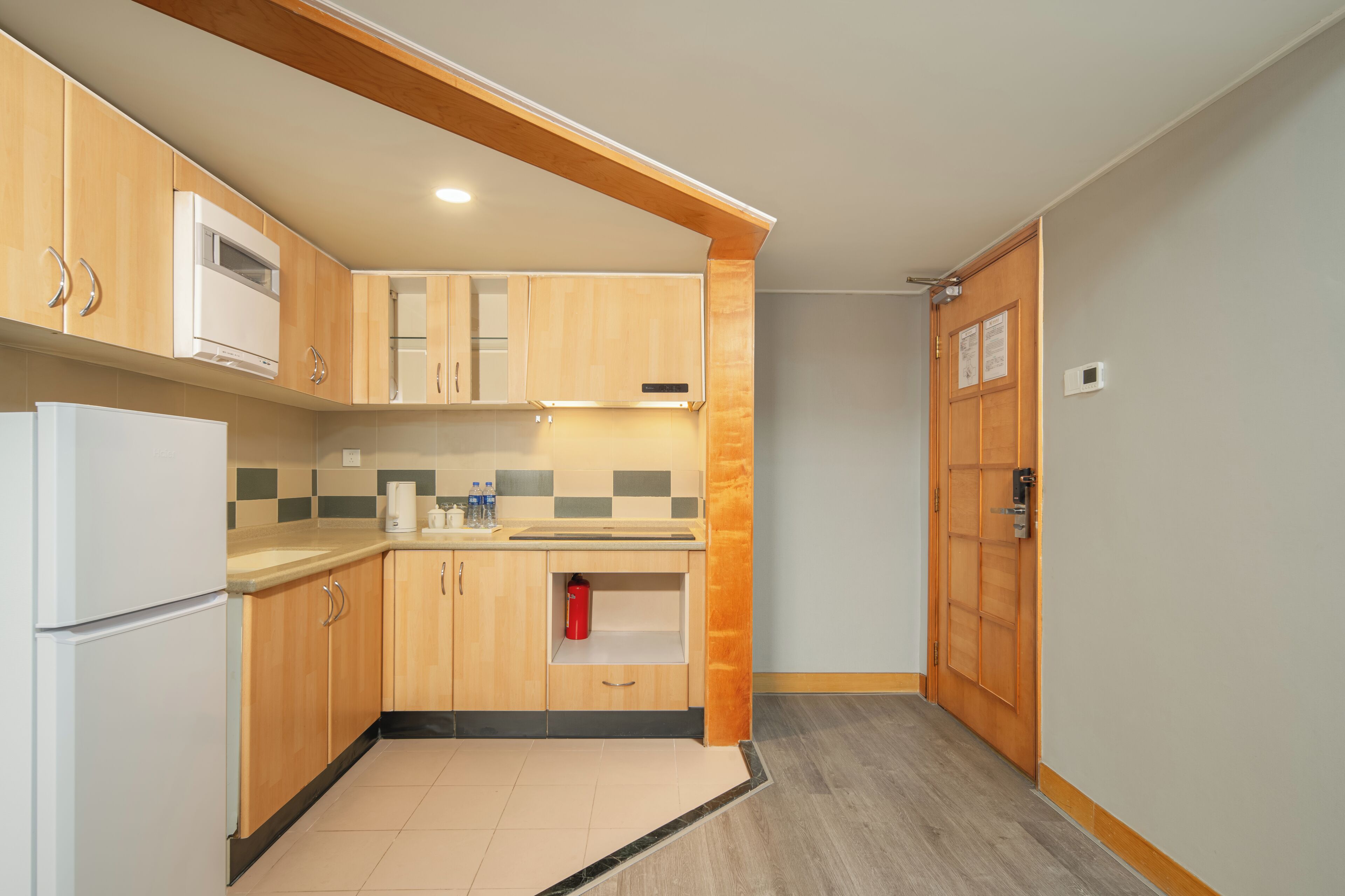 A modern kitchen with wooden cabinets, a white refrigerator, and a tiled backsplash.