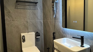 Ein modernes Badezimmer mit Toilette, Waschbecken und Dusche.