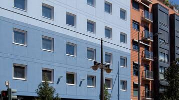 Un hôtel à plusieurs étages, doté d’une façade bleue, de nombreuses fenêtres et d’une entrée bien visible avec une enseigne.