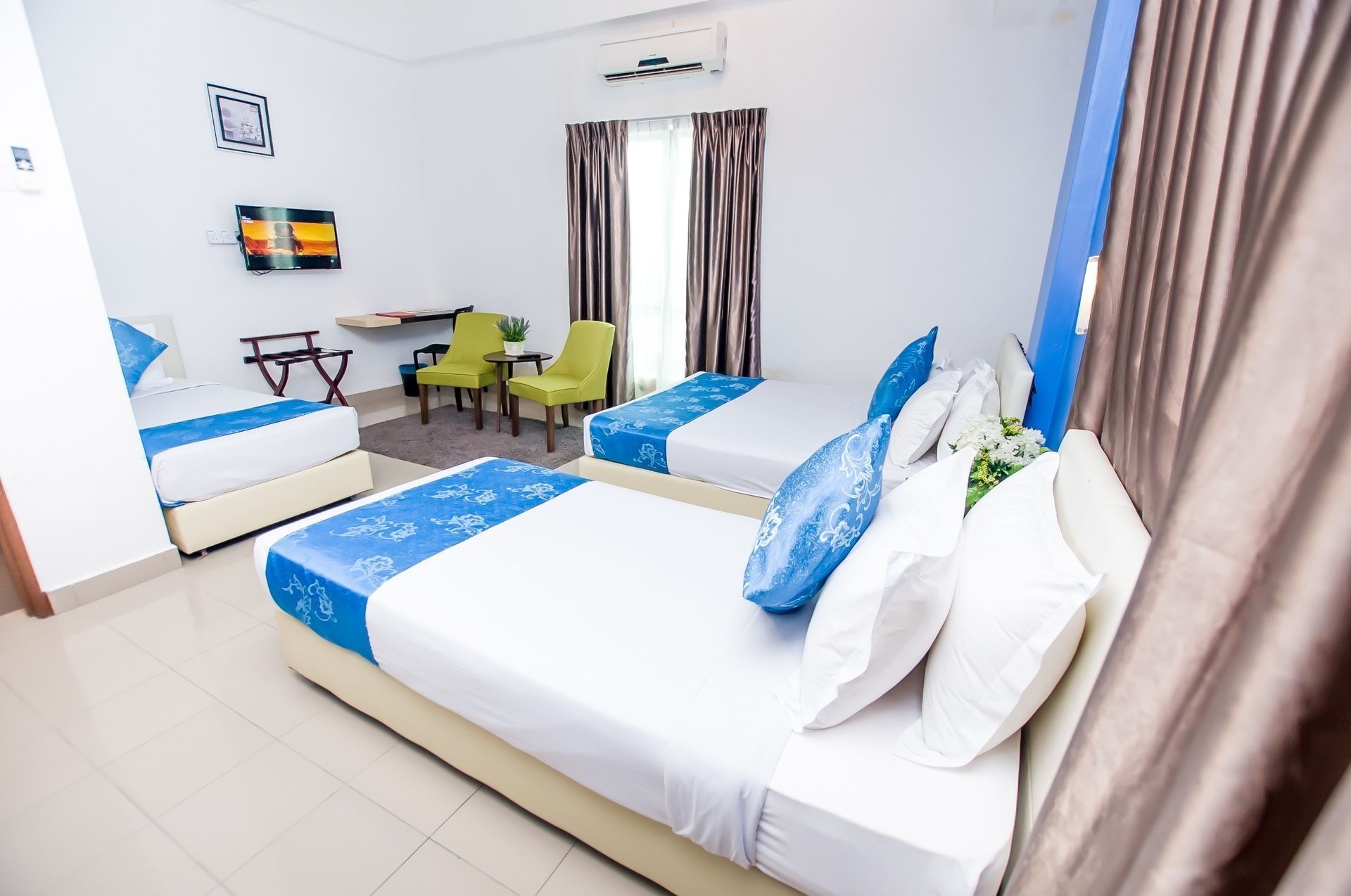 A hotel room with two beds, a desk, and a chair.