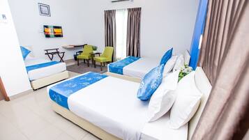 A hotel room with two beds, a desk, and a chair.