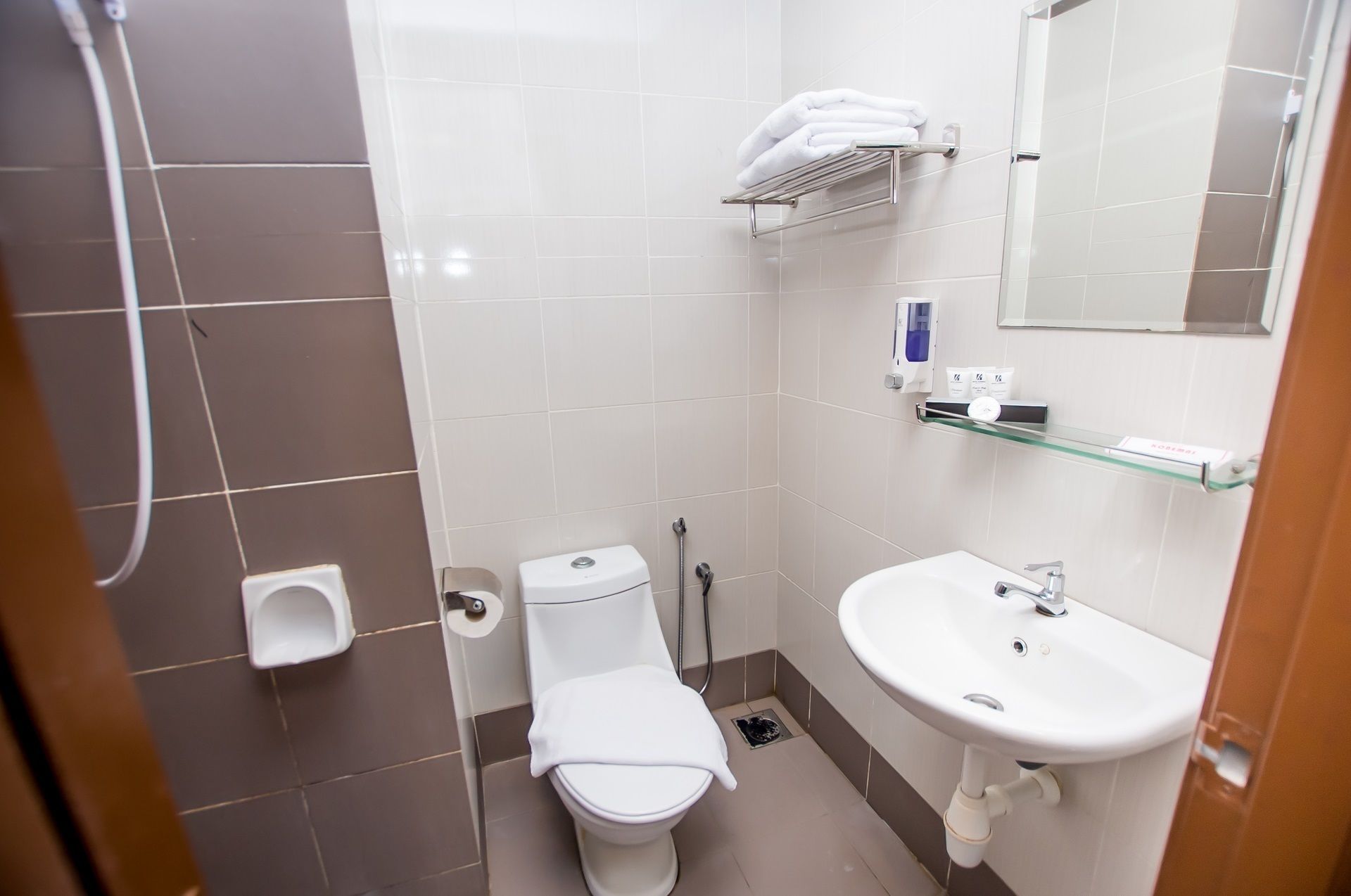 Un baño pequeño y moderno con inodoro, lavamanos y ducha.