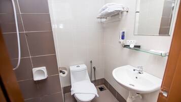 Un baño pequeño y moderno con inodoro, lavamanos y ducha.