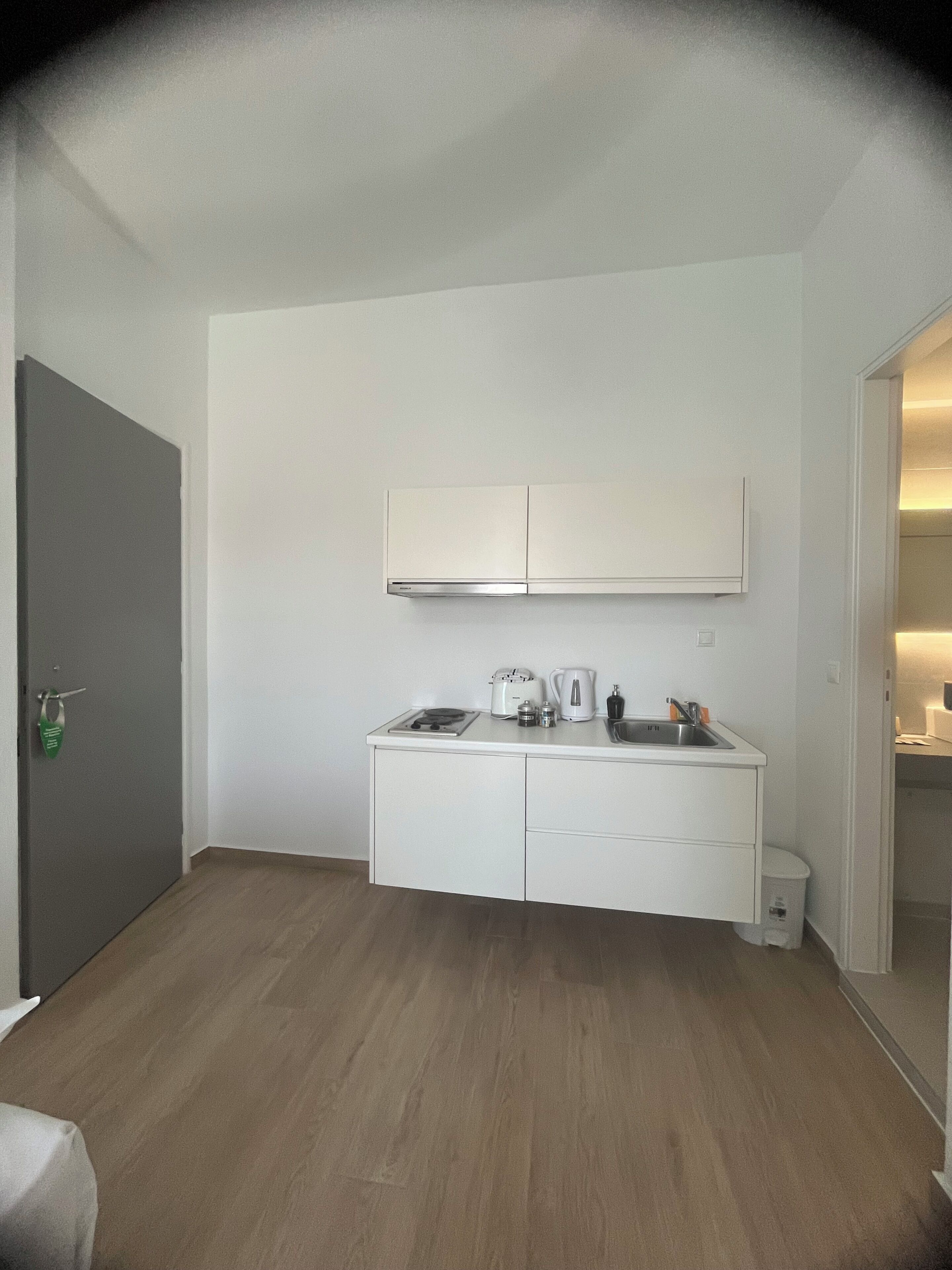 Una cocina compacta con horno integrado, cafetera y lavabo.
