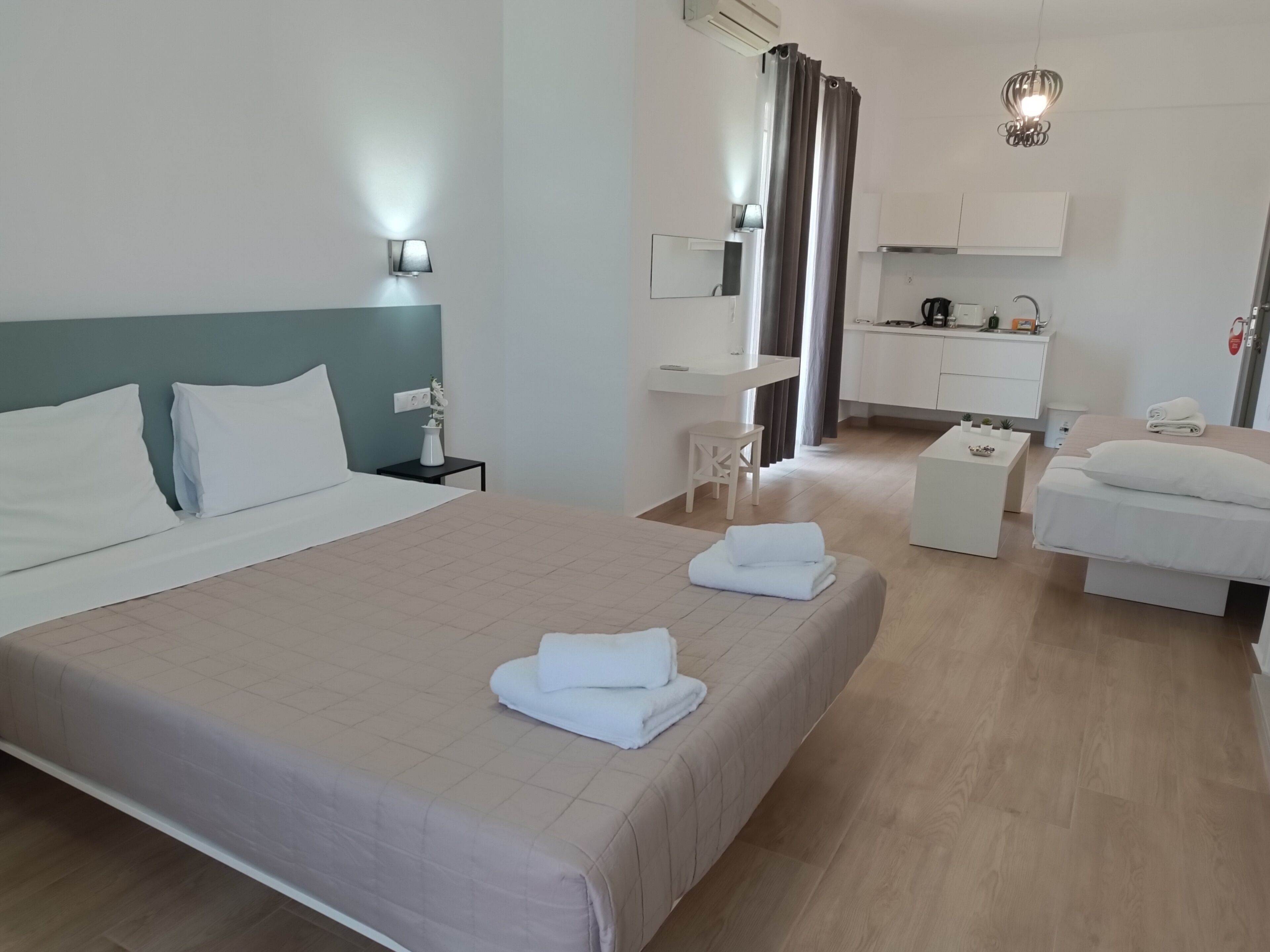 Une chambre d’hôtel avec un lit, une table de chevet, une lampe et une vue sur la cuisine.