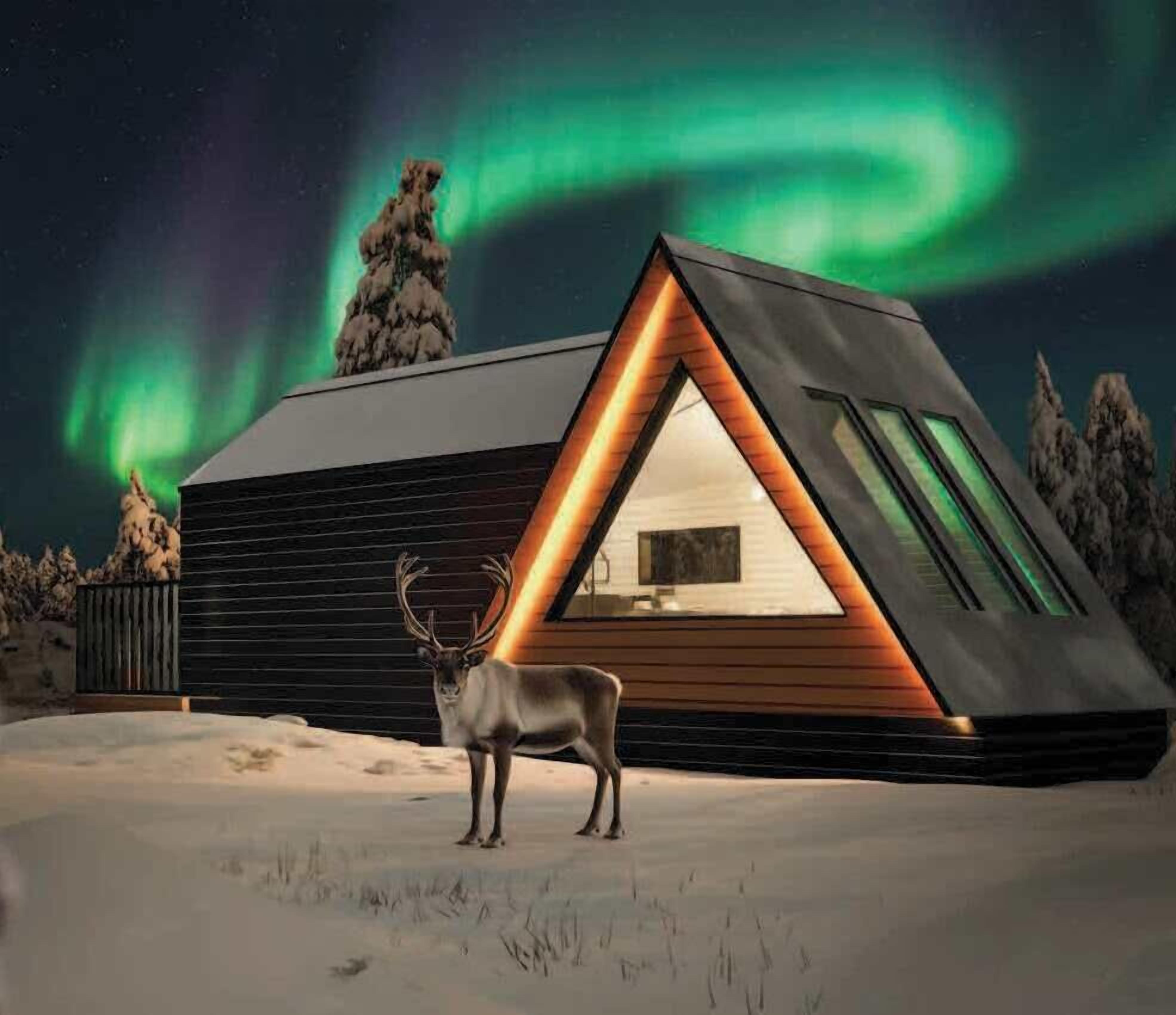 A modern cabin with a triangular roof, a glass door, and a deer in the foreground.